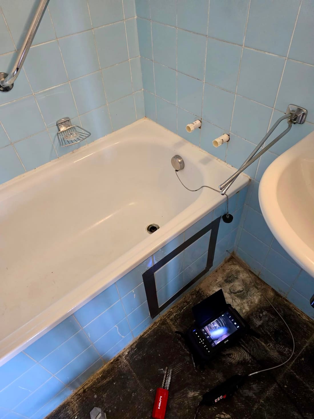 Baignoire au tablier quadrillé, caméra d’inspection posée au sol